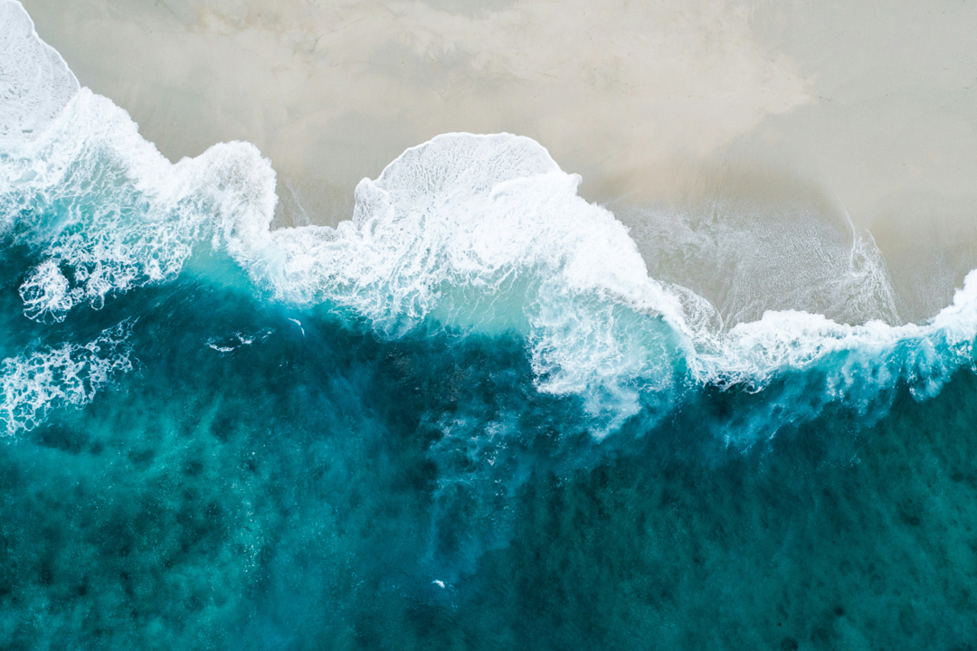 NOAA Innovates | Ocean-Based Climate Resilience Accelerator, powered by VentureWell; photo of ocean wave breaking over the sand