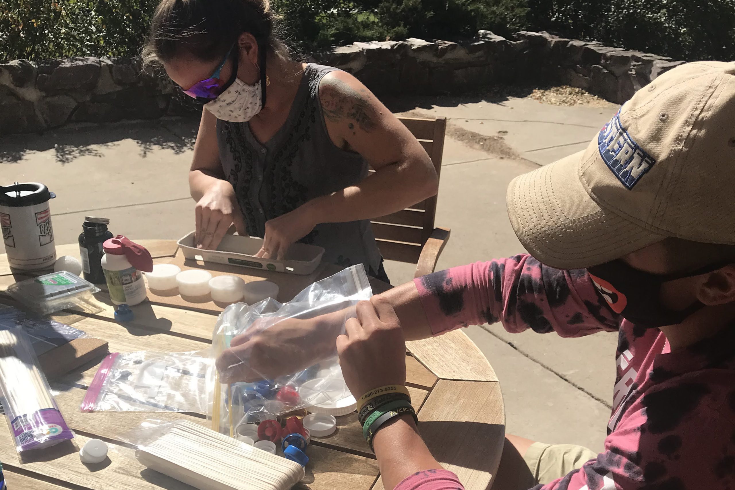 Teaching the Value of Waste; people working with recycled materials at an outdoor table