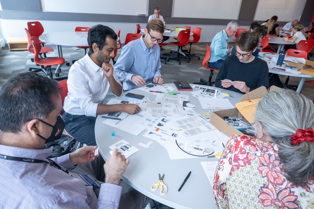 VIA Summit; photo of attendees at a past event sitting around a table doing an activity