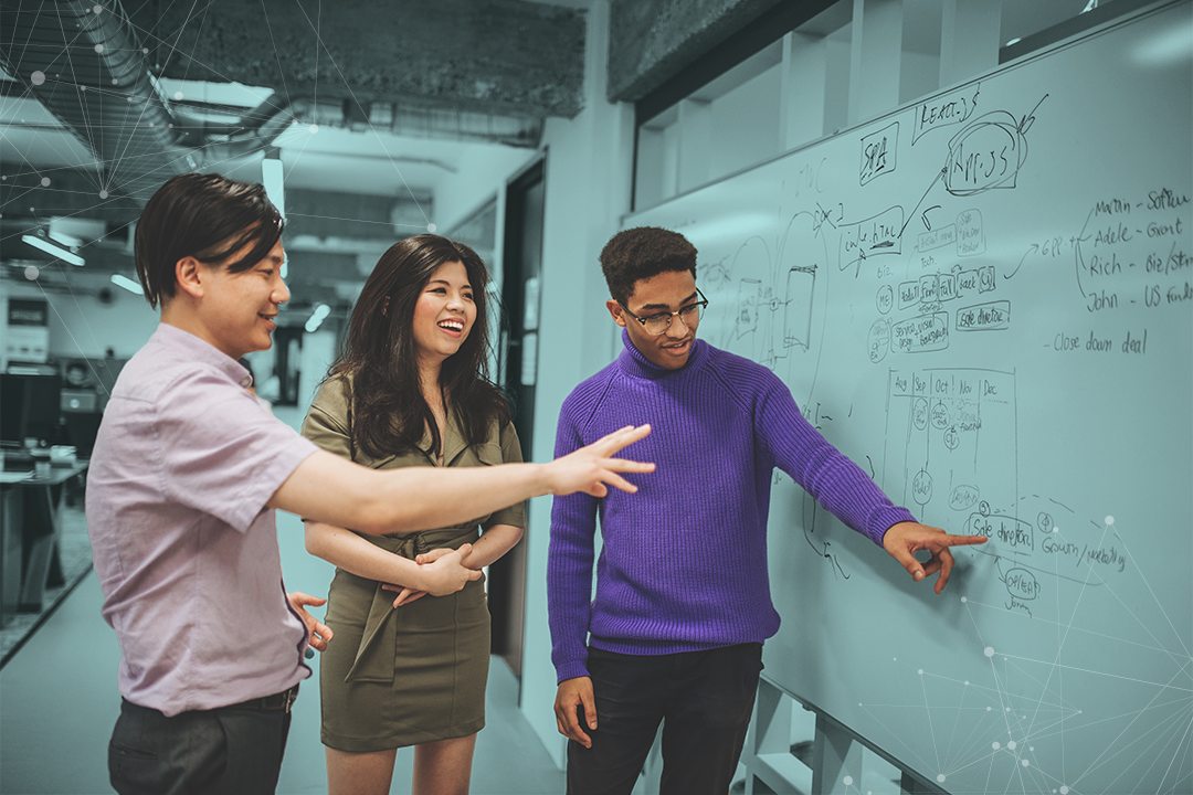 The Entrepreneur Forum; photo of mentor with mentees at a whiteboard